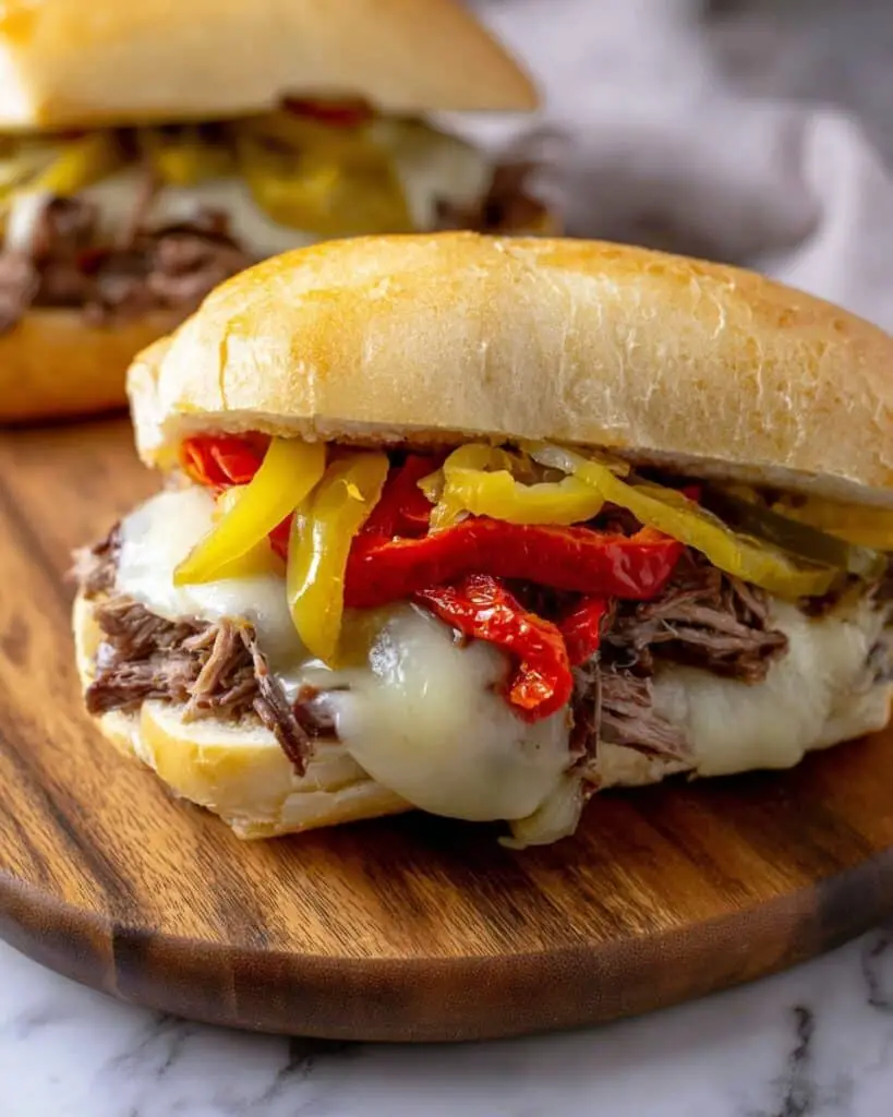 Italian Beef Sandwiches with Melty Cheese, Pepperoncini, and Flavorful Broth Recipe