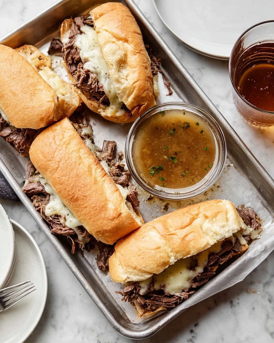 The image shows a metal tray with four sandwiches made of soft white bread rolls, each sandwich filled with shredded dark brown beef and melted white cheese, creating a mix of textures from the crunchy bread to the tender meat and smooth cheese. In the center of the tray is a small round glass bowl filled with a light brown broth with bits of meat floating inside. The tray sits on a white marbled surface, with a blurred white plate on the side and a woman's hand holding a glass of a brown drink near the top right corner. The sandwiches and broth look warm and ready to eat. photo taken with an iphone --ar 4:5 --v 7