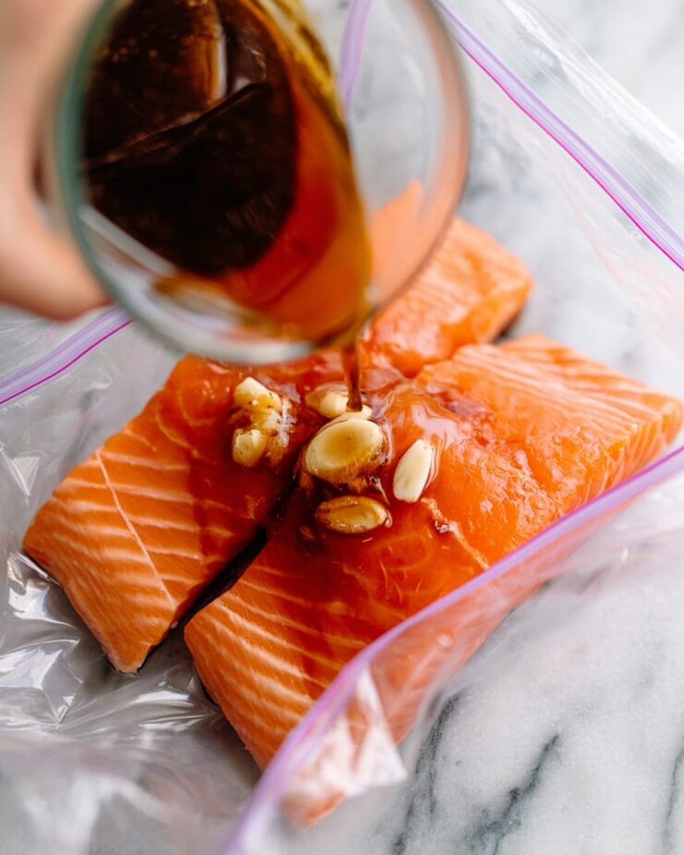 A close-up image shows two bright orange salmon fillets inside a clear plastic zipper bag that lies on a white marbled surface. On top of the salmon, several slices of garlic and a splash of dark brown sauce are visible. A woman's hand is holding a glass container, pouring more dark sauce into the bag. The colors are bright and natural, and the texture of the raw salmon is smooth and slightly shiny. Photo taken with an iphone --ar 4:5 --v 7