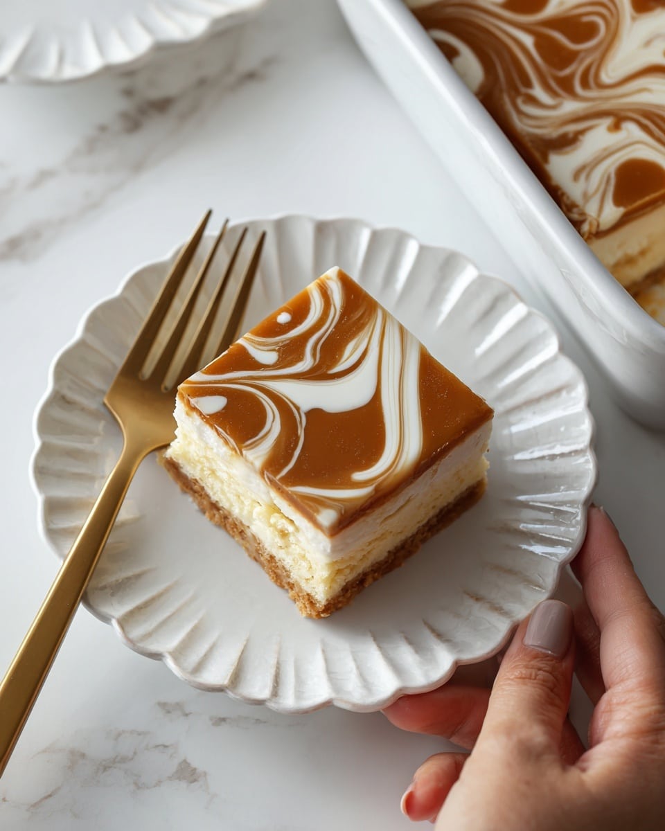 A square piece of dessert with three visible layers sits on a white scalloped plate over a white marbled surface. The bottom layer is pale cream, the middle layer is light yellow, and the top layer is a smooth brown glaze with white curved lines in a wavy pattern. Next to the plate is a golden fork with a woman's hand holding it. In the top right corner, part of a white square baking dish shows the remaining dessert with the same brown and white wavy design on top. Photo taken with an iphone --ar 4:5 --v 7