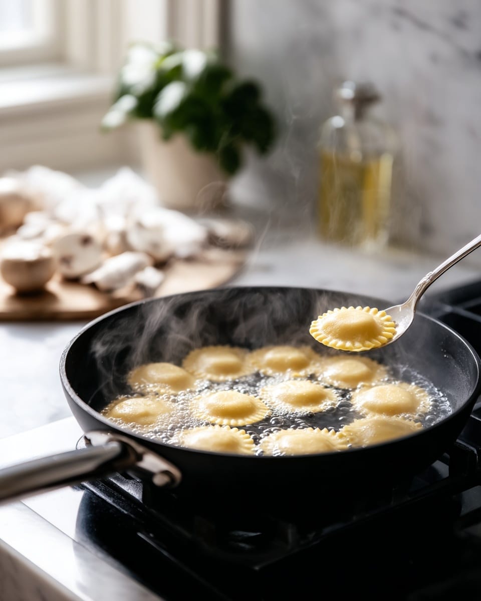 A black pan filled with water is boiling on a stove with eight creamy yellow round ravioli pasta pieces floating on the surface. Some ravioli edges are crimped while others appear smooth, and steam rises gently from the water. A silver spoon is lifting one ravioli on the right side of the pan. In the background, there is a blurred white marbled countertop with a potted green plant, a bottle with a light yellow liquid, and some sliced white mushrooms. The scene is softly lit with natural light. Photo taken with an iphone --ar 4:5 --v 7