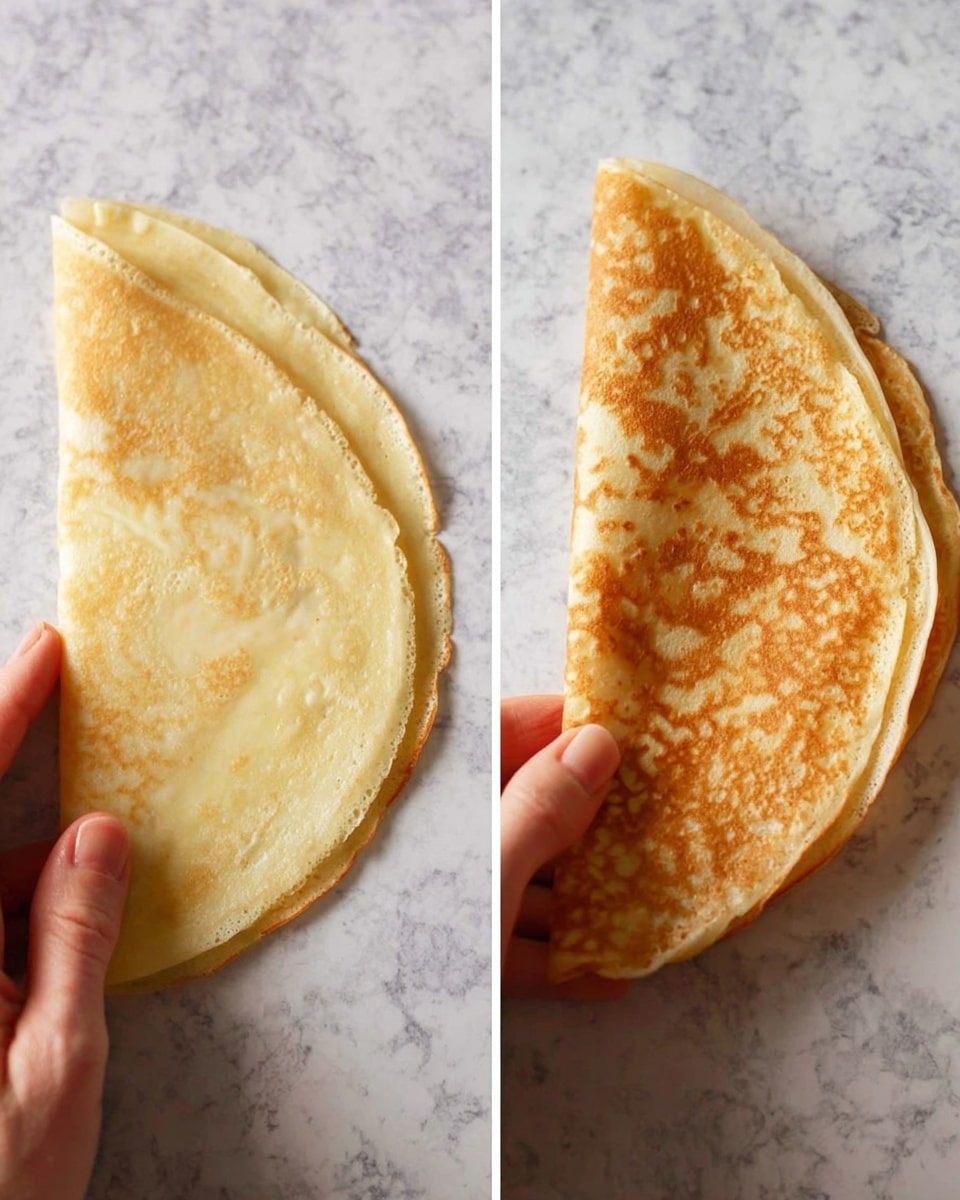 The image shows two stages of folding a thin, light golden-brown crepe on a white marbled surface. On the left, a woman's hand gently folds the crepe in half, revealing its smooth, slightly textured surface with darker golden spots. On the right, a woman's hand holds the crepe folded again into a quarter, showing the delicate layers and soft texture with light spots of browning on both sides, all resting on the same white marbled background. photo taken with an iphone --ar 4:5 --v 7