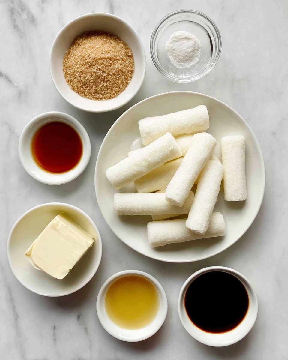 The image shows six white bowls and one white plate on a white marbled surface. In the center, the white plate is filled with several white cylindrical rice cakes. Around the plate, starting from the top left, there is a small white bowl with brown sugar, a small white bowl with clear liquid, a small white bowl containing a block of cream-colored tofu or cheese, a small white bowl with honey-colored liquid, and a small white bowl with dark brown soy sauce or similar liquid. Everything is neatly arranged, giving a clean and organized look. photo taken with an iphone --ar 4:5 --v 7