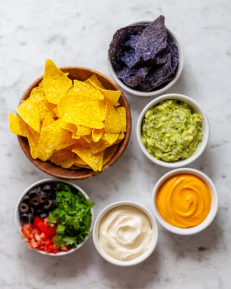 The image shows six small white bowls and a wooden bowl arranged on a white marbled surface. The wooden bowl holds bright yellow tortilla chips with a light texture. Surrounding it are six white bowls: the top one contains dark blue corn tortilla chips, the next to the left has green guacamole with a smooth, creamy texture, below it is an orange cheese sauce with a slightly rough texture, below that is a beige sour cream with a smooth swirl on top, and to the left of the blue chips bowl is a white bowl with several chopped ingredients including green cilantro, black olives, and red tomatoes. The colors and layers are clearly shown. photo taken with an iphone --ar 4:5 --v 7