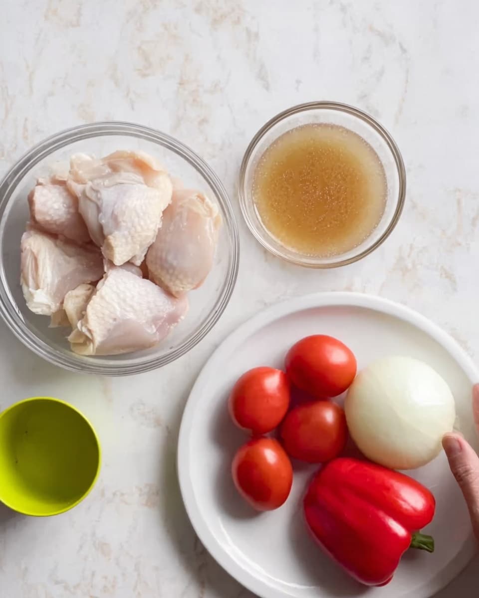 The image shows a top view of three clear glass bowls and a white plate on a white marbled surface. The first glass bowl contains raw chicken pieces with pale pink and white skin tones. The second glass bowl holds a light brown liquid, appearing thin and translucent. The white plate holds four red tomatoes, one red bell pepper, and a white onion, with the tomatoes and pepper showing smooth, shiny textures. A small lime green cup is also placed on the surface, with no visible contents. A woman's hand is reaching towards the glass bowls from the right side. Photo taken with an iphone --ar 4:5 --v 7