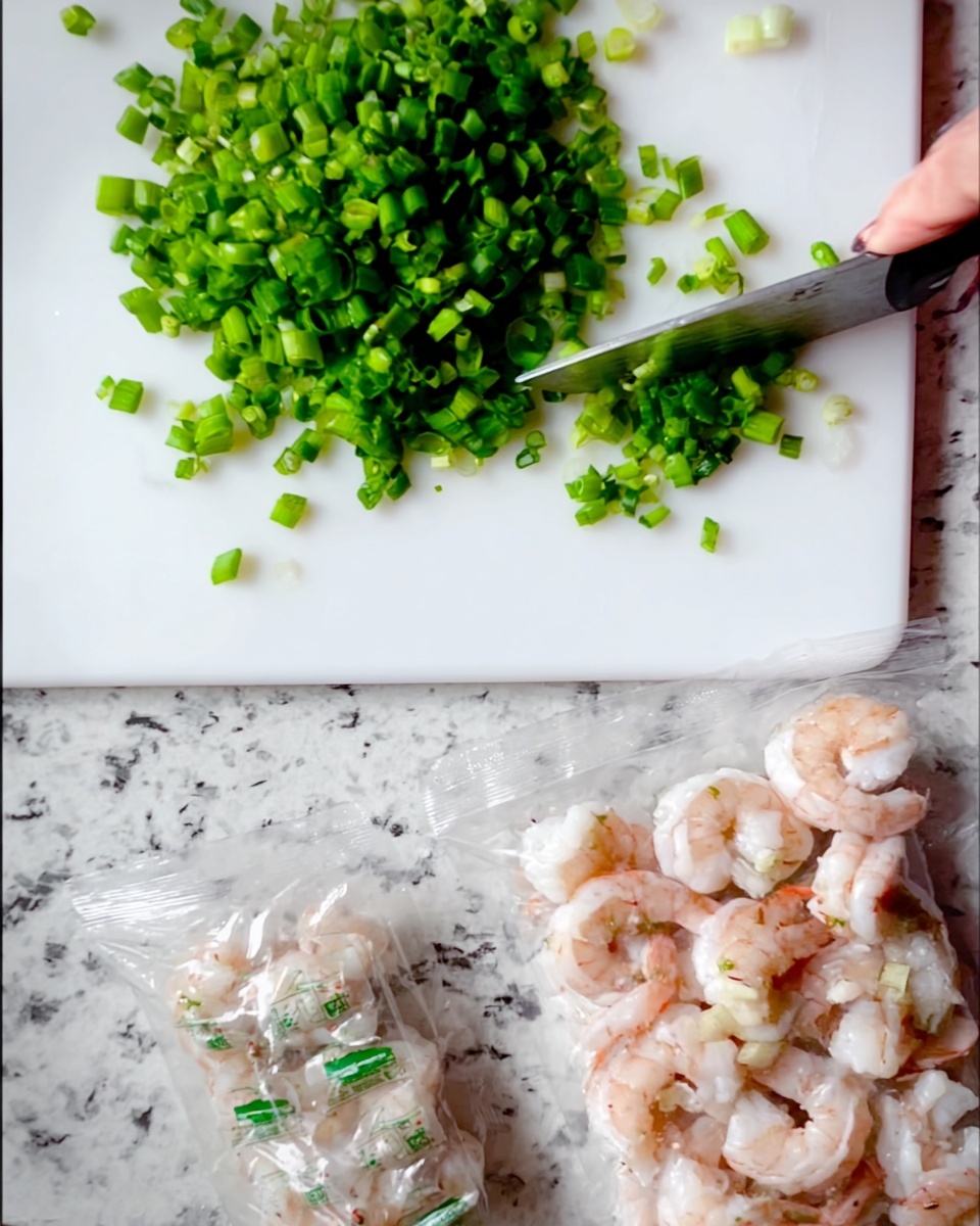 A close-up image shows a white cutting board on a white marbled countertop. On the cutting board, there is a pile of green chopped scallions, with a woman's hand holding a knife cutting more scallions into small rounds. Three clear plastic bags filled with peeled shrimp are placed on the white marbled countertop near the cutting board. The focus is on the bright green scallions and the small pinkish shrimp through the plastic bags. Photo taken with an iphone --ar 4:5 --v 7