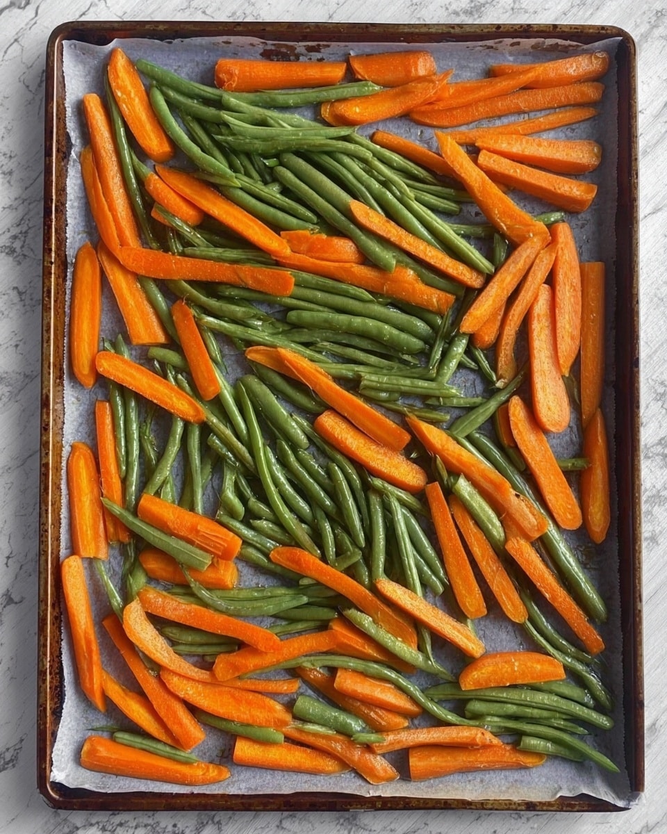 The image shows a baking tray lined with parchment paper placed on a white marbled surface. On the tray, there are two types of vegetables spread out evenly: bright orange carrot sticks and vibrant green string beans. The carrot sticks are cut into long rectangular pieces and are scattered throughout the tray among the green string beans, which remain whole and slightly curved. Both vegetables have a fresh, slightly shiny surface, indicating they might be ready to roast or have just been roasted. The overall color contrast between the orange carrots and green beans is clear and vibrant. photo taken with an iphone --ar 4:5 --v 7