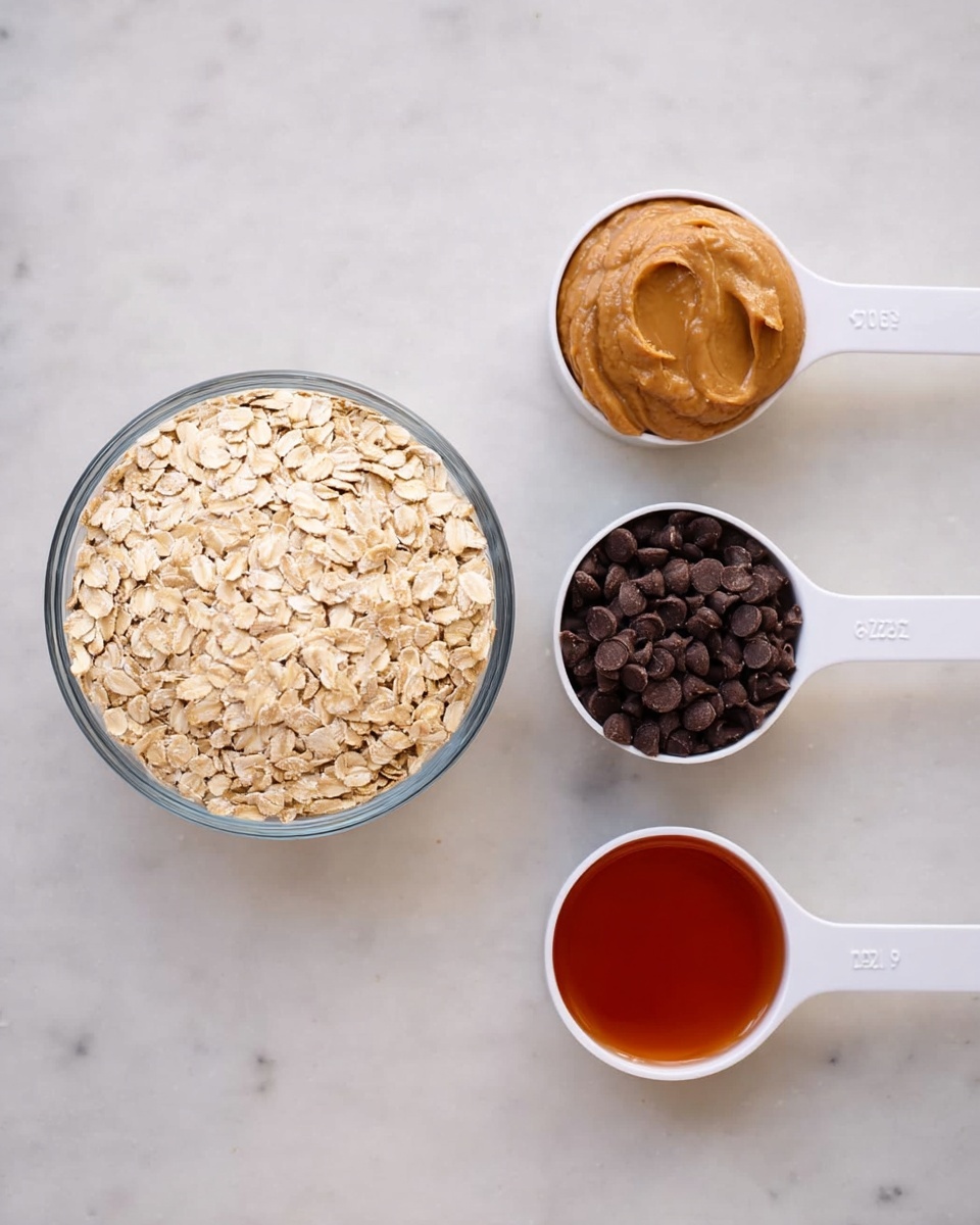 The image shows a clear glass bowl filled with light beige oats on the left. Next to it, there are three white measuring cups arranged in a horizontal line: the first cup holds smooth light brown peanut butter, the second cup contains small dark brown chocolate chips, and the third cup has a reddish-brown liquid, possibly honey or syrup. All the items are placed on a white marbled surface. photo taken with an iphone --ar 4:5 --v 7