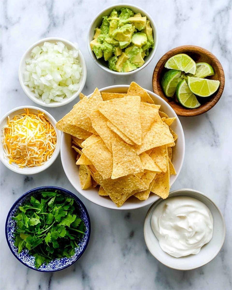 The image shows six small white and wooden bowls arranged on a white marbled surface. The largest white bowl in the center holds many yellow corn tortilla chips with a rough texture, arranged unevenly to form a mound. Surrounding it, going clockwise from top left, is a small white bowl with a heap of mixed shredded yellow and white cheese, another small wooden bowl filled with smooth, white sour cream, a group of lime wedges with bright green skin and pale green flesh, a small white bowl with finely chopped white onions, a small white bowl with bright green avocado chunks, and a small white bowl filled with fresh green cilantro leaves. Photo taken with an iphone --ar 4:5 --v 7