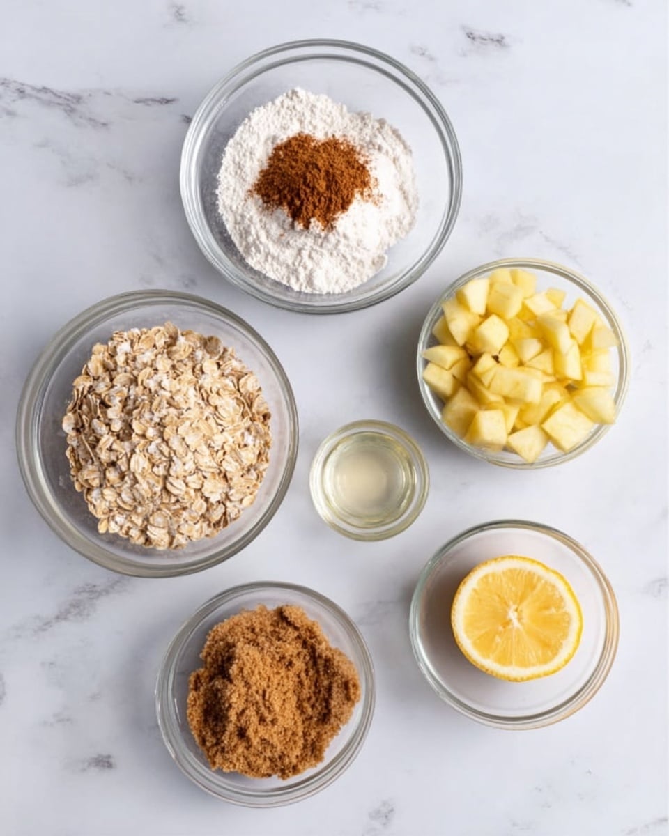 The image shows five clear glass bowls arranged on a white marbled surface. The top bowl contains a small mound of white flour with a pile of brown cinnamon powder in the center. To the left is a bowl filled with light brown oats. The bottom left bowl holds soft brown sugar with a grainy texture. To the right center, a bowl is filled with chopped pale yellow apple pieces. Below that is a small bowl with clear, shiny liquid, likely lemon juice, next to a halved lemon showing its inside. The setup looks neat and clean, highlighting each ingredient separately. Photo taken with an iphone --ar 4:5 --v 7