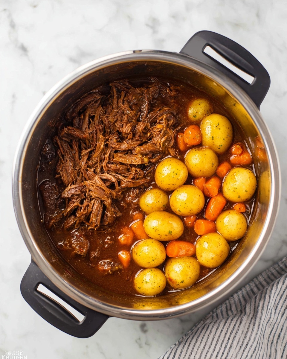 The image shows a stainless steel pot containing a stew separated into two main parts: on the left side, shredded brown meat with a moist, soft texture sitting in a rich, dark brown sauce, and on the right side, round yellow baby potatoes mixed with chunky orange carrot pieces, all coated in the same sauce. The pot has black handles and sits on a white marbled surface with a striped cloth partially visible on the bottom right. photo taken with an iphone --ar 4:5 --v 7