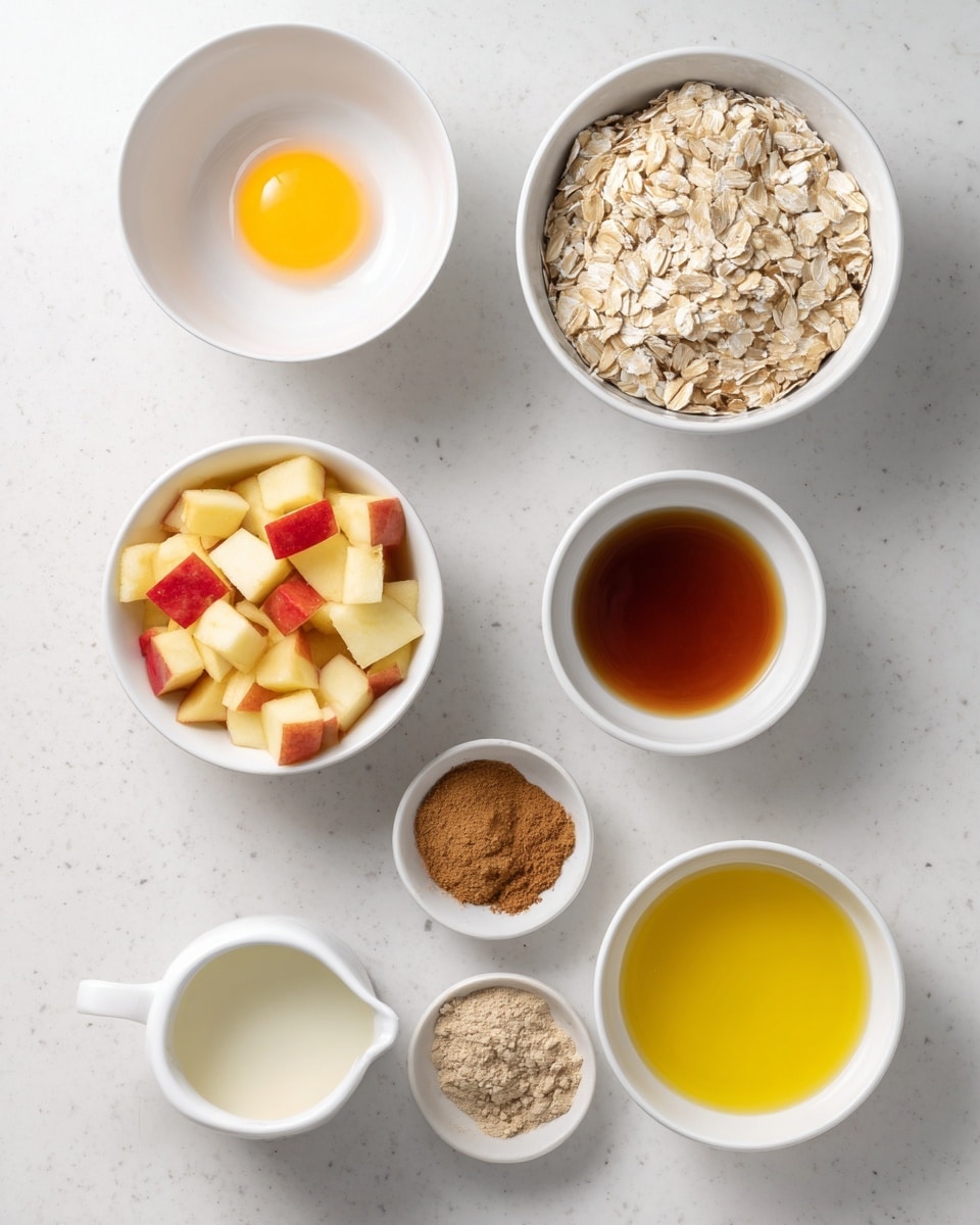 The image shows seven white bowls arranged on a white marbled surface. In the top left, a bowl holds one raw egg with a bright yellow yolk. To the right is a larger bowl filled with dry oats, pale beige and slightly textured. Below that, a medium bowl contains diced apples with red and yellow skin. In the center, a small bowl holds three different powdered spices in brown and beige colors, placed side by side. To the left, a small bowl has a dark amber liquid, likely syrup or vanilla. Near the bottom, a white small jug contains a cream-colored liquid, and to its right, a small bowl holds a golden-yellow liquid, possibly oil. The setup is neat and bright, capturing the ingredients clearly. photo taken with an iphone --ar 4:5 --v 7