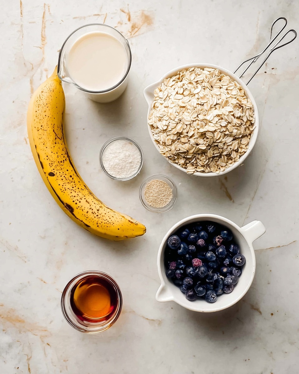 The image shows a flat lay of baking ingredients on a white marbled surface. At the top right, there is a white measuring cup full of rolled oats with a metal handle. Below it to the right is a white measuring cup filled with small, dark blueberries. To the left of the blueberries is a ripe yellow banana with brown spots, curving from the bottom right toward the center. Above the banana is a small glass bowl with white powder. In the center is a small glass cup with a dark amber liquid, and below it to the left is a small glass bowl with a light brown powder. On the left side, there is a clear glass measuring cup filled with a creamy white liquid. photo taken with an iphone --ar 4:5 --v 7