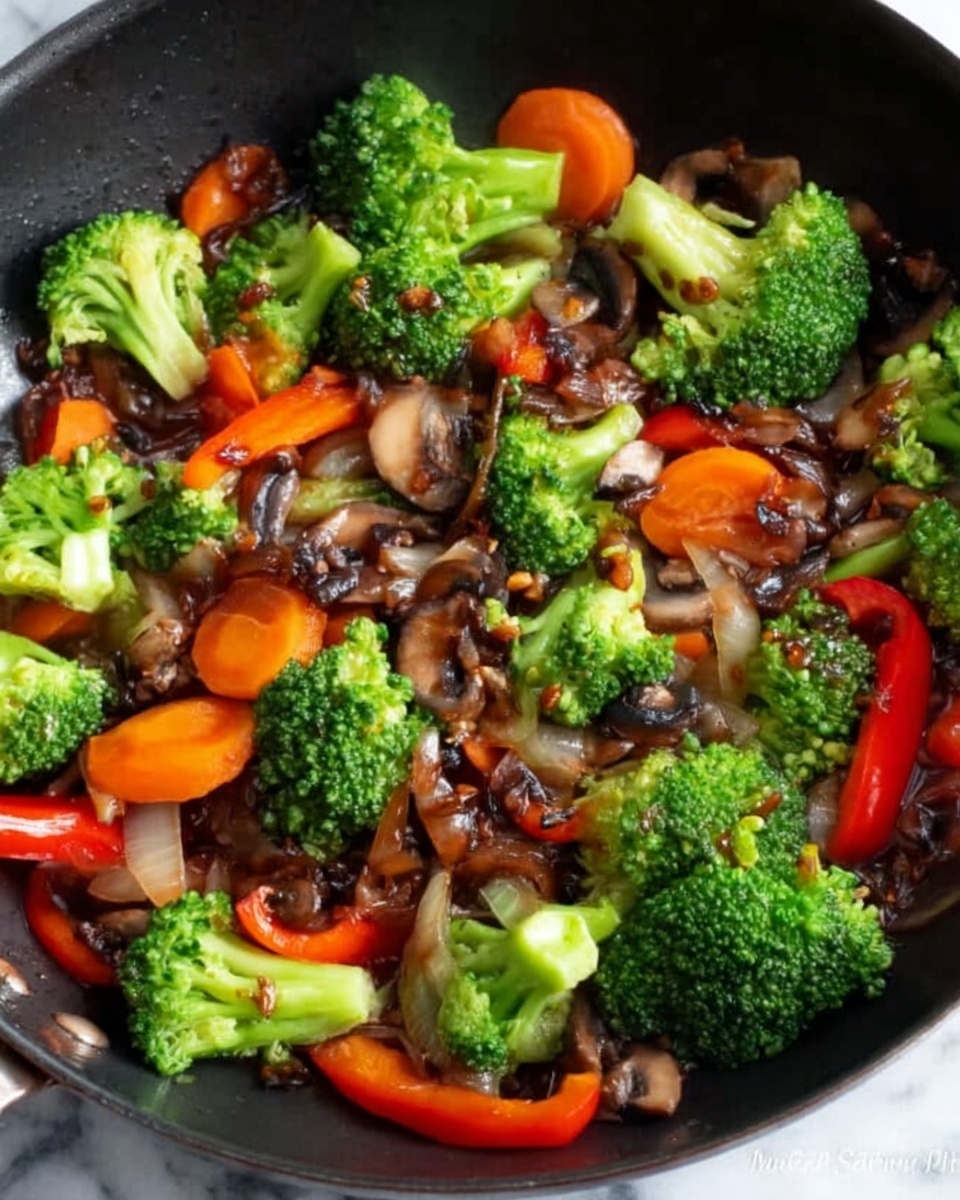 A close-up view of a black pan filled with a colorful stir-fry dish. The bottom layer is a mix of thinly sliced dark brown mushrooms and glossy light brown onions. On top of this layer, there are bright green broccoli florets scattered all around the pan. Among the broccoli, some slices of vibrant orange carrots and a few pieces of red bell pepper add more color. The textures vary from soft and shiny mushrooms to firm, fresh vegetables. The whole dish looks warm and freshly cooked on a white marbled surface. Photo taken with an iphone --ar 4:5 --v 7