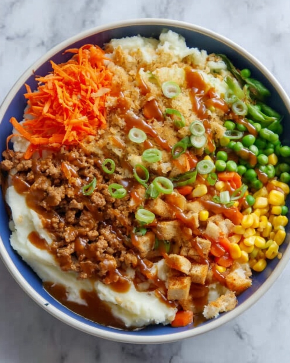 The image shows a white bowl filled with a colorful layered dish. The bottom layer is white and creamy, likely mashed potatoes. On top of that are different sections of food: golden-brown cooked ground meat on one side, crispy light brown small pieces next to it, and bright orange shredded vegetables beside those. There is also a colorful mix of small green beans, orange carrots, and yellow corn near the edge. A brown sauce drizzles over the dish, and green onion slices are scattered over the top. The bowl is placed on a white marbled surface. photo taken with an iphone --ar 4:5 --v 7