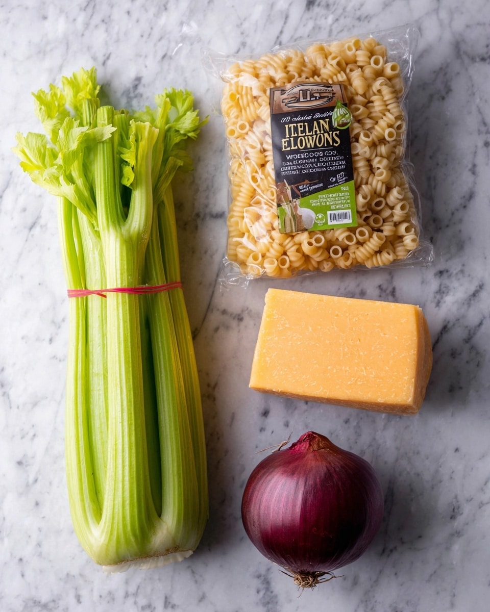 A bunch of green celery stalks tied with a red band is placed on the upper left side, next to a white marbled surface. Below the celery, there is a clear plastic package of light yellow elbow macaroni with a black and green label reading