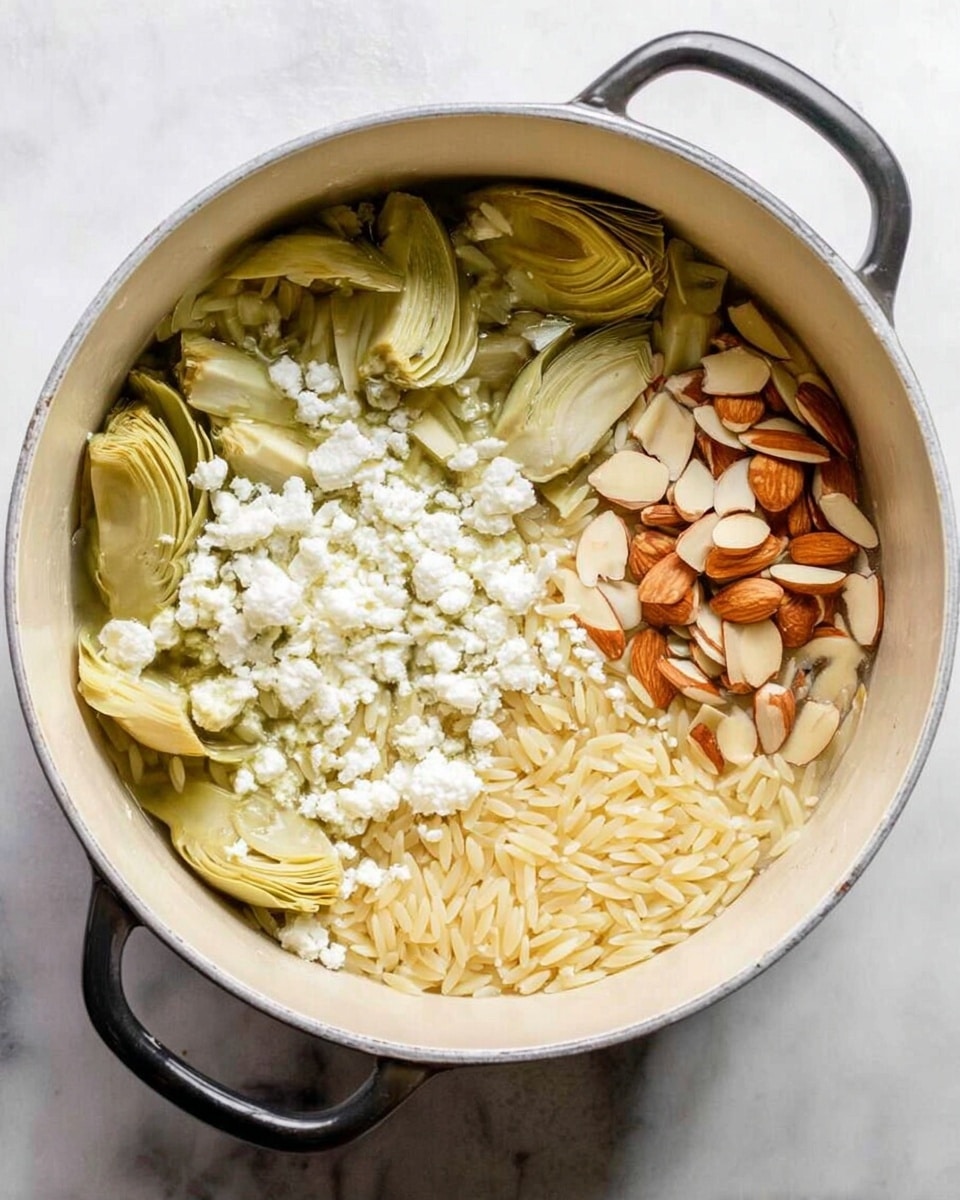 A white pot filled with three main layers of ingredients: at the bottom, there is a layer of orzo pasta in light beige color; on the left side, there are pale green artichoke heart halves; on the right side, a layer of thinly sliced light brown almonds; and on the top left, a sprinkle of white feta cheese crumbles. The pot handle is black and the pot sits on a white marbled surface. photo taken with an iphone --ar 4:5 --v 7