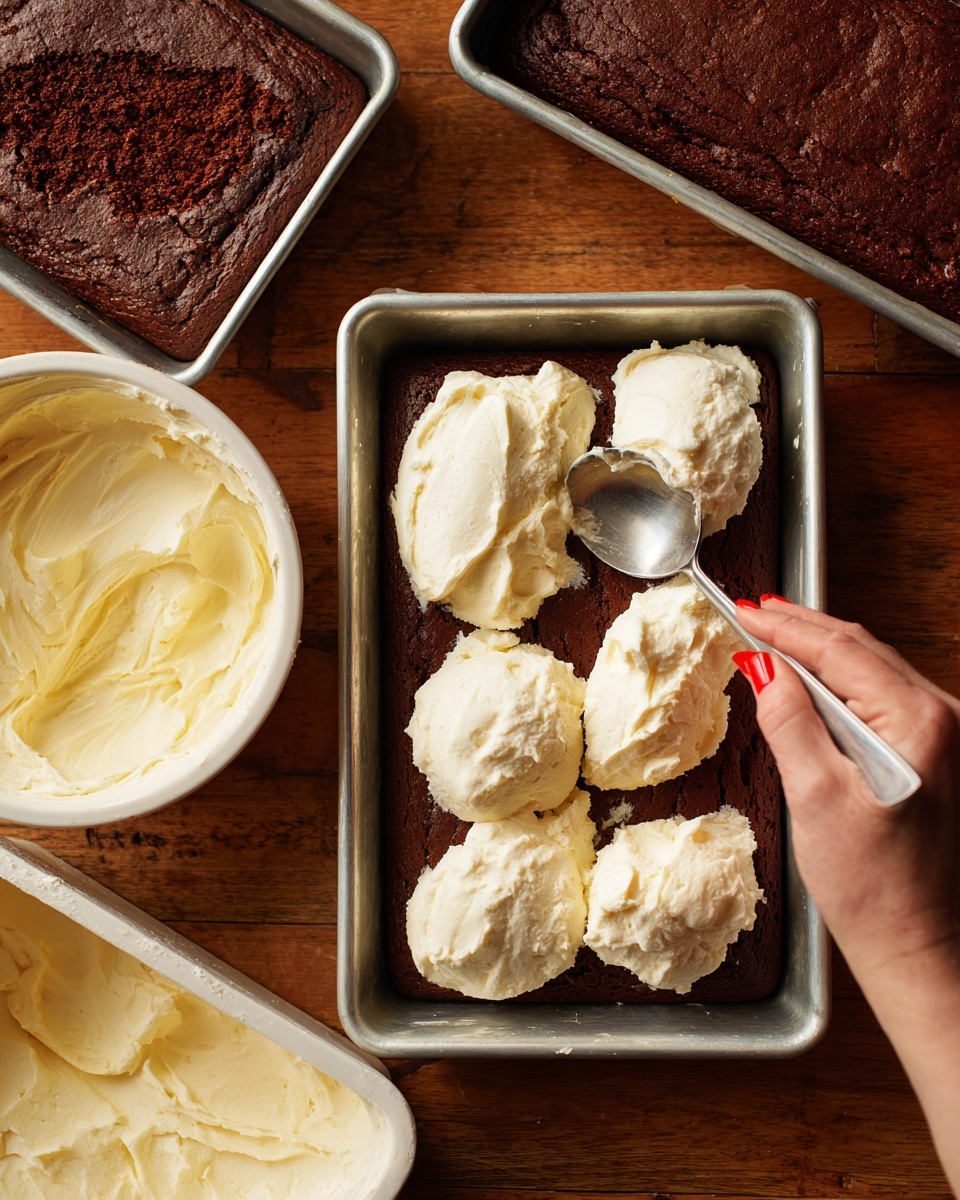 The image shows a rectangular metal baking tray filled with a dark brown chocolate cake layer. On top of this cake layer, there are six large, uneven scoops of creamy white frosting being spread with a silver spoon held by a woman's hand with red painted nails. To the left of the tray, there is another similar tray with uniced chocolate cake, and in the bottom left corner, there is an open white tub filled with more white frosting. The whole scene is set on a wooden surface. photo taken with an iphone --ar 4:5 --v 7