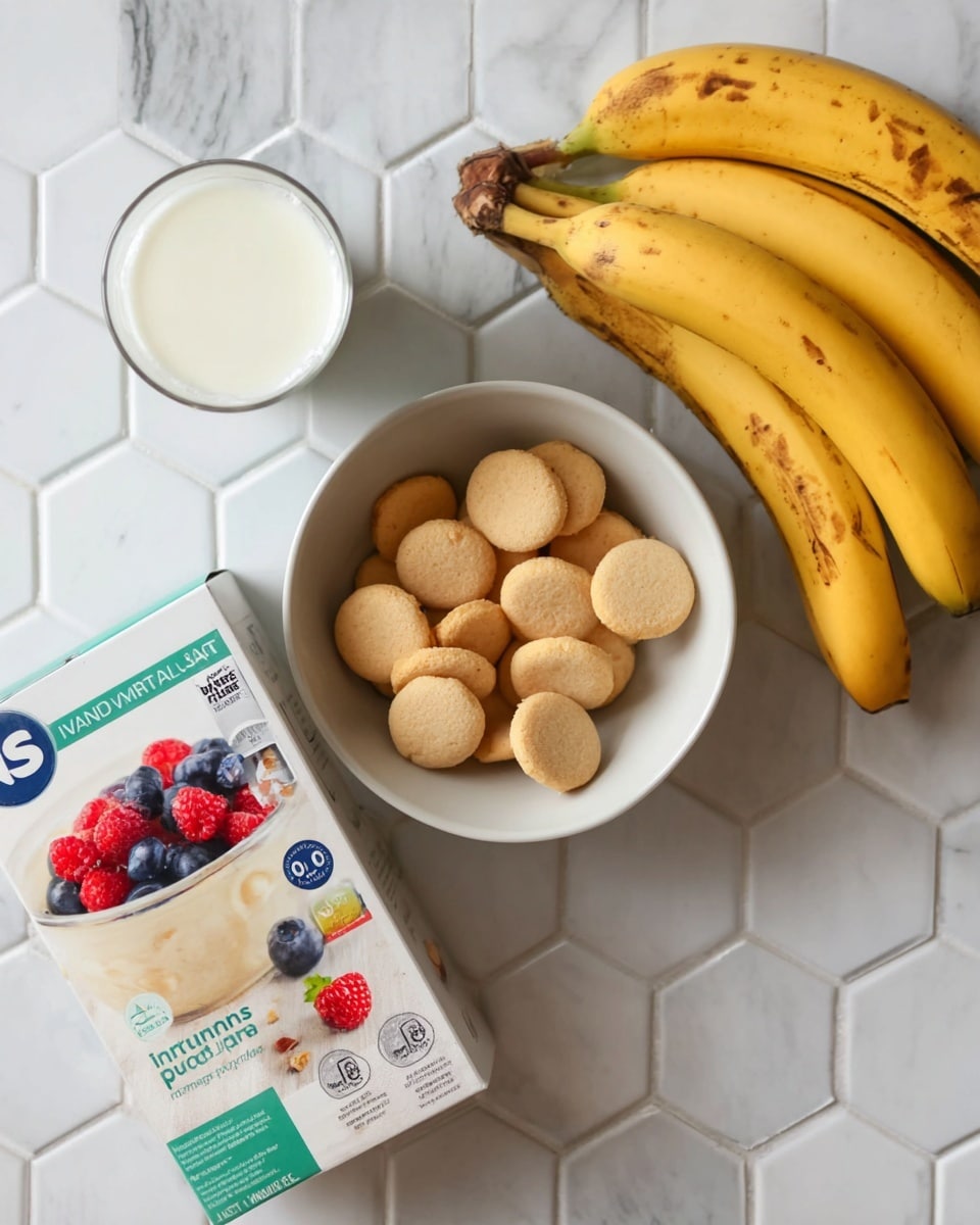 The image shows a white bowl filled with small round cookies that are golden brown and light beige, placed on a white marbled hexagonal tile surface. To the right of the bowl, there are three yellow bananas with some spots and marks on their peel. Below the bananas, there is a box of vanilla instant pudding with pictures of pudding topped with blueberries and raspberries on it. To the left of the bananas and pudding box, there is a clear glass cup filled with milk. The whole setup is on a white marbled surface. photo taken with an iphone --ar 4:5 --v 7