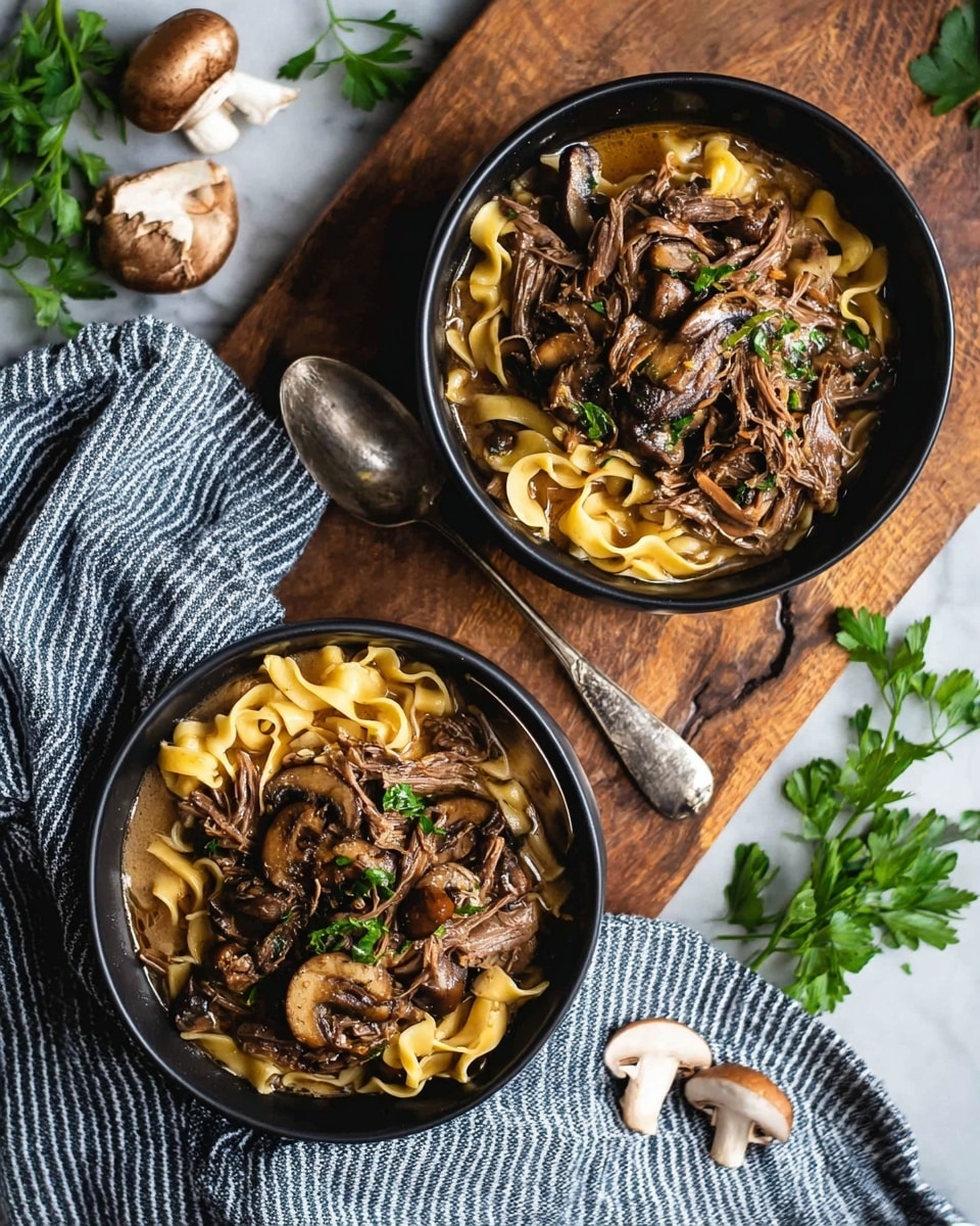 Two black bowls filled with three layers of food sit on a wooden board over a white marbled surface. The bottom layer shows wide yellow noodles that look soft. Above the noodles, there are brown shredded meat pieces spread evenly. The top layer has sliced brown mushrooms mixed with small green parsley leaves sprinkled throughout. The food is bathed in a light brown sauce that adds a glossy shine. A silver spoon rests next to the bowls on a cloth with blue stripes. Around the bowls are whole mushrooms and green parsley leaves. photo taken with an iphone --ar 4:5 --v 7