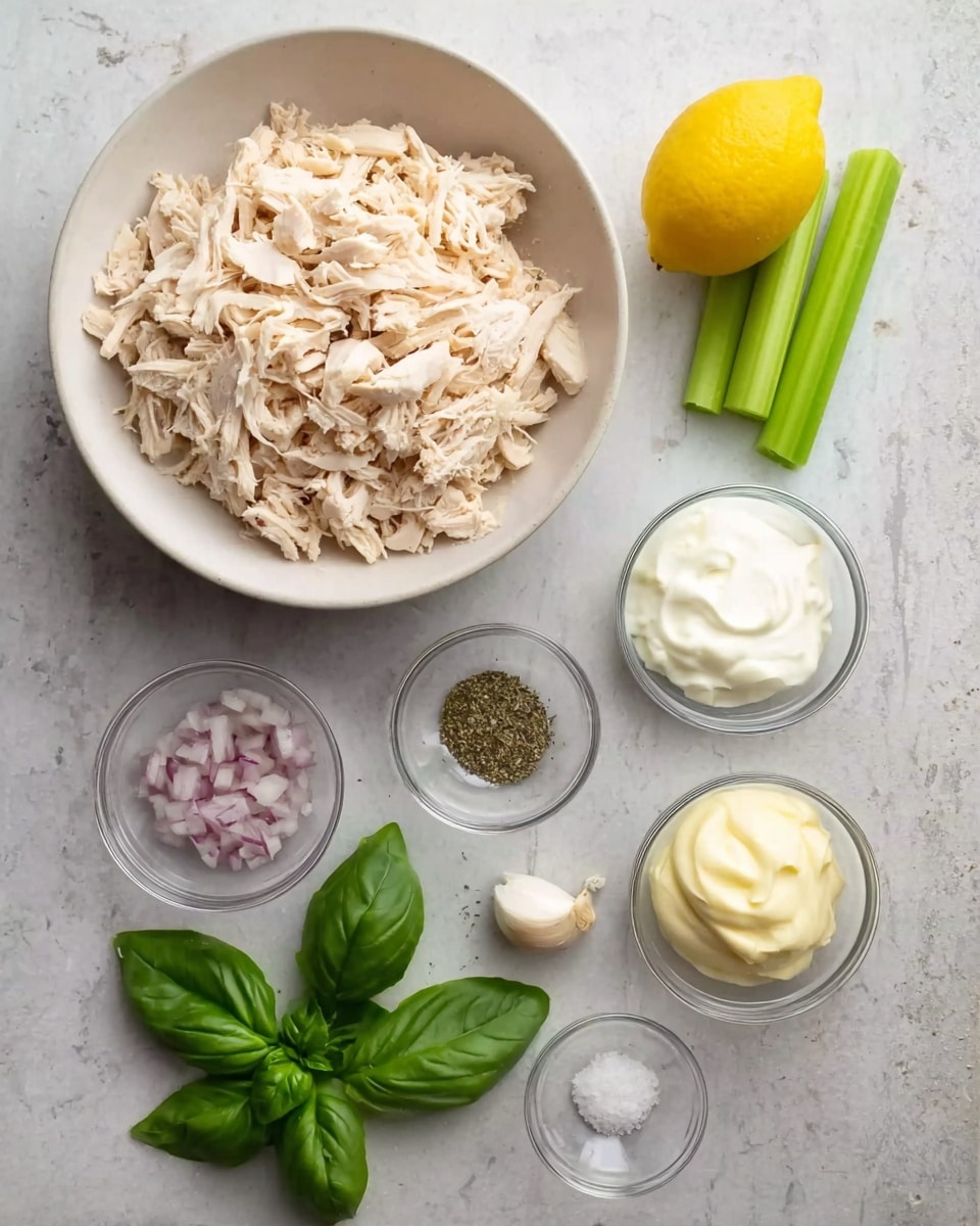 A large white bowl filled with shredded light beige cooked chicken pieces sits on a white marbled surface. To the right of the bowl is a whole bright yellow lemon. Below the lemon, there are three green celery sticks laid side by side. Near the celery are fresh green basil leaves. Below and to the left of the chicken bowl are four small glass bowls. One contains finely chopped light purple shallots, another has smooth white sour cream, the third holds creamy pale yellow mayonnaise, and the last one is empty. Next to these bowls are a single white garlic clove, a sprinkle of black pepper, and a small pinch of white salt scattered on the surface. The setup is neat and well spaced. Photo taken with an iphone --ar 4:5 --v 7