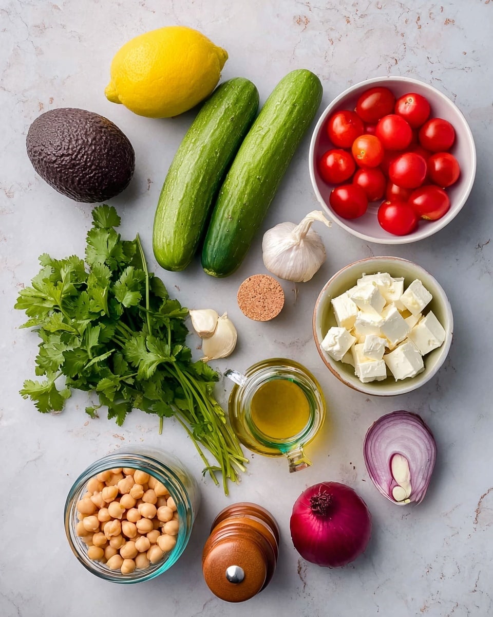 The image shows a bright and fresh spread of salad ingredients on a white marbled texture. There is a bright yellow lemon and a dark purple avocado near the top left, with two whole green cucumbers and a bunch of fresh green cilantro below them. To the right, a small white bowl full of red cherry tomatoes sits above a small white bowl filled with evenly cubed white cheese. A single small red onion and a clove of garlic are placed near the bottom center. On the upper right, a can of chickpeas is opened with light brown beans visible inside. In the middle, there is a clear small bottle of olive oil with a cork stopper, flanked by two wooden salt and pepper shakers. Everything is arranged neatly with natural colors and textures. photo taken with an iphone --ar 4:5 --v 7