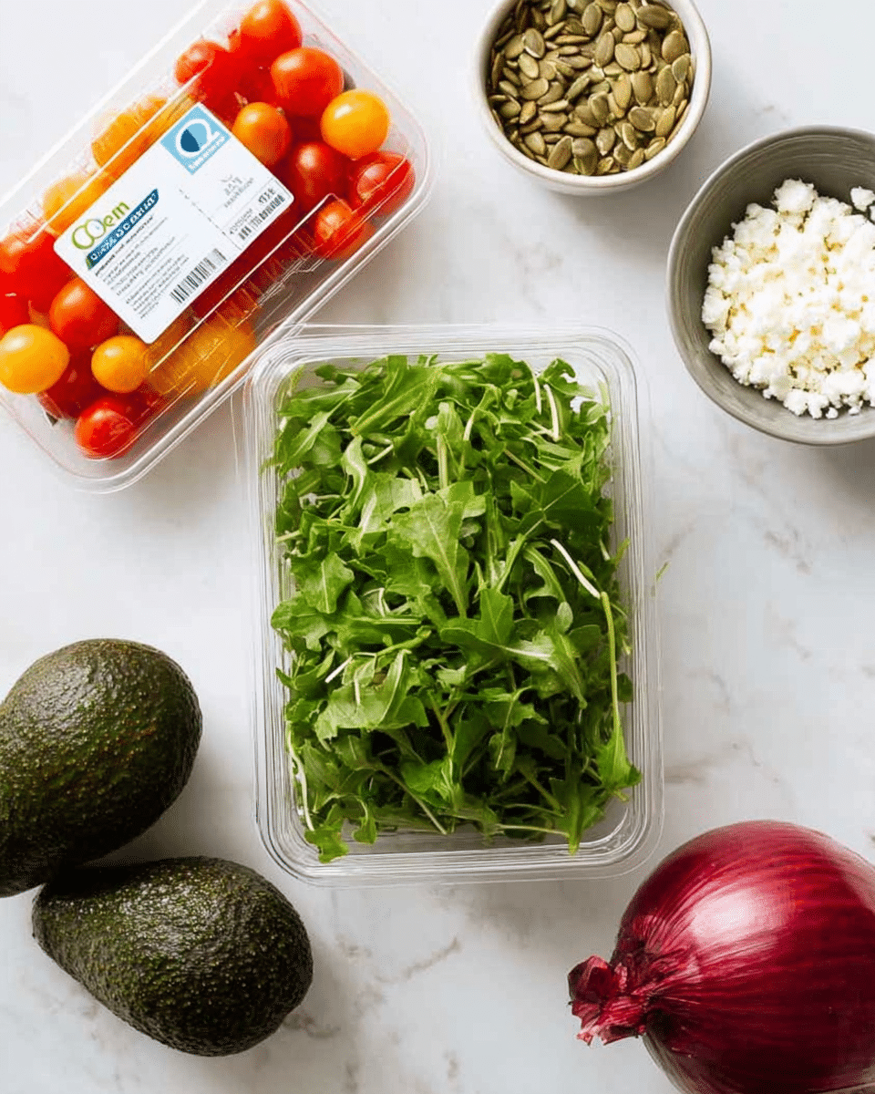 A clear plastic container filled with bright green baby arugula leaves sits in the center on a white marbled surface. To the left of the container, there are two dark green avocados with rough skin and a clear plastic box of red and orange cherry tomatoes. Above the arugula container is a small white bowl filled with light brown pumpkin seeds, and to the right, a small grayish bowl holds white crumbled cheese. A deep red onion with shiny, smooth skin is placed on the right side of the image, all arranged neatly on the white marbled background. photo taken with an iphone --ar 4:5 --v 7