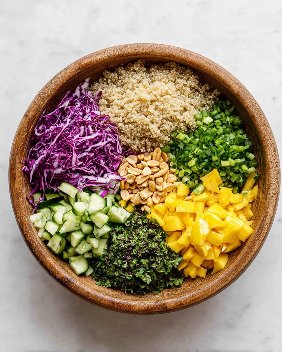 A wooden bowl holds six neatly separated layers of ingredients arranged in a circular pattern on a white marbled background. Starting from the top center and moving clockwise, there is a light beige layer of cooked quinoa with a soft texture, followed by thinly shredded bright purple cabbage. Next is a layer of finely chopped green onions with a fresh, crisp look. Below that is a layer of small, bright yellow mango cubes, offering a smooth and juicy texture. Toward the bottom left, fresh cucumber pieces with a rich green color and a slight gloss sit next to a mound of chopped dark green herbs, possibly cilantro or parsley. Above the herbs and cucumber, there is a small pile of roasted peanuts with a light brown color and smooth surface. The bowl is placed on a clean white marbled surface, giving the image a fresh and bright feel. Photo taken with an iphone --ar 4:5 --v 7