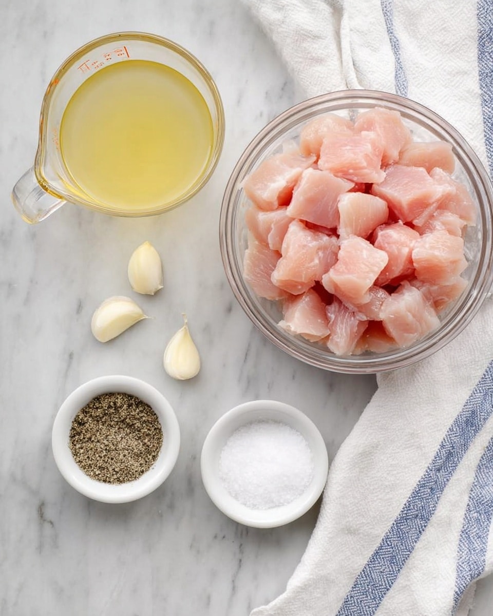The image shows a top view of several ingredients arranged on a white marbled surface. In the center left, there is a clear glass bowl filled with pink, cubed raw chicken pieces. Below and slightly to the right, a small white bowl contains a mix of black pepper and white salt. To the left of this bowl, there is another small white bowl with a pale yellow liquid, likely oil. Above these bowls, a clear measuring cup holds a light yellow broth or stock. Two peeled garlic cloves sit on the surface to the left side of the ingredients. On the right edge, part of a white cloth with blue stripes is visible. Photo taken with an iphone --ar 4:5 --v 7