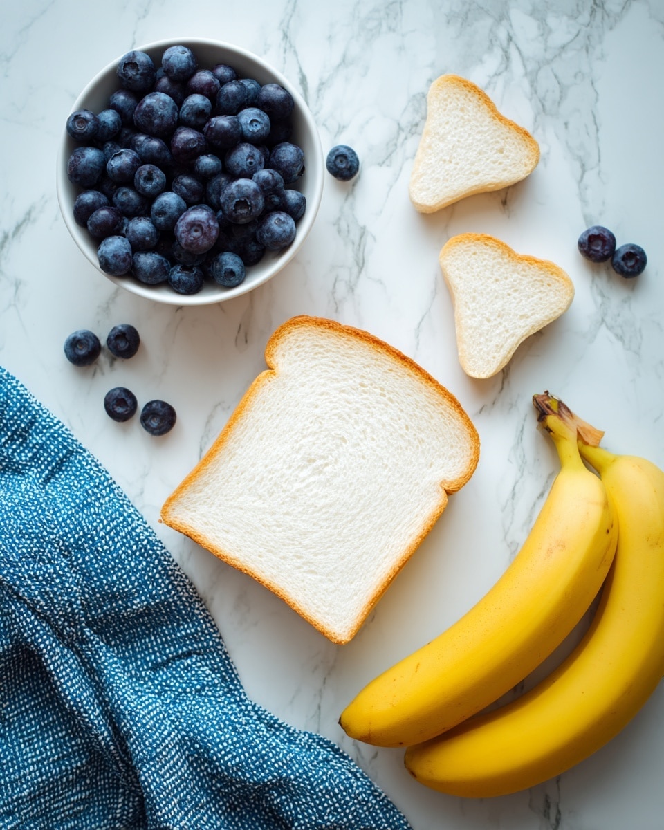 The image shows a single slice of white bread placed flat on a white marbled surface with two small triangular pieces of bread positioned above it, resembling ears. To the left of the bread is a white bowl filled with fresh blueberries, with a few blueberries scattered outside the bowl. To the right of the bread, there are three yellow bananas resting on the surface. A blue and white textured cloth is draped partially in the bottom left corner. The photo taken with an iphone --ar 4:5 --v 7