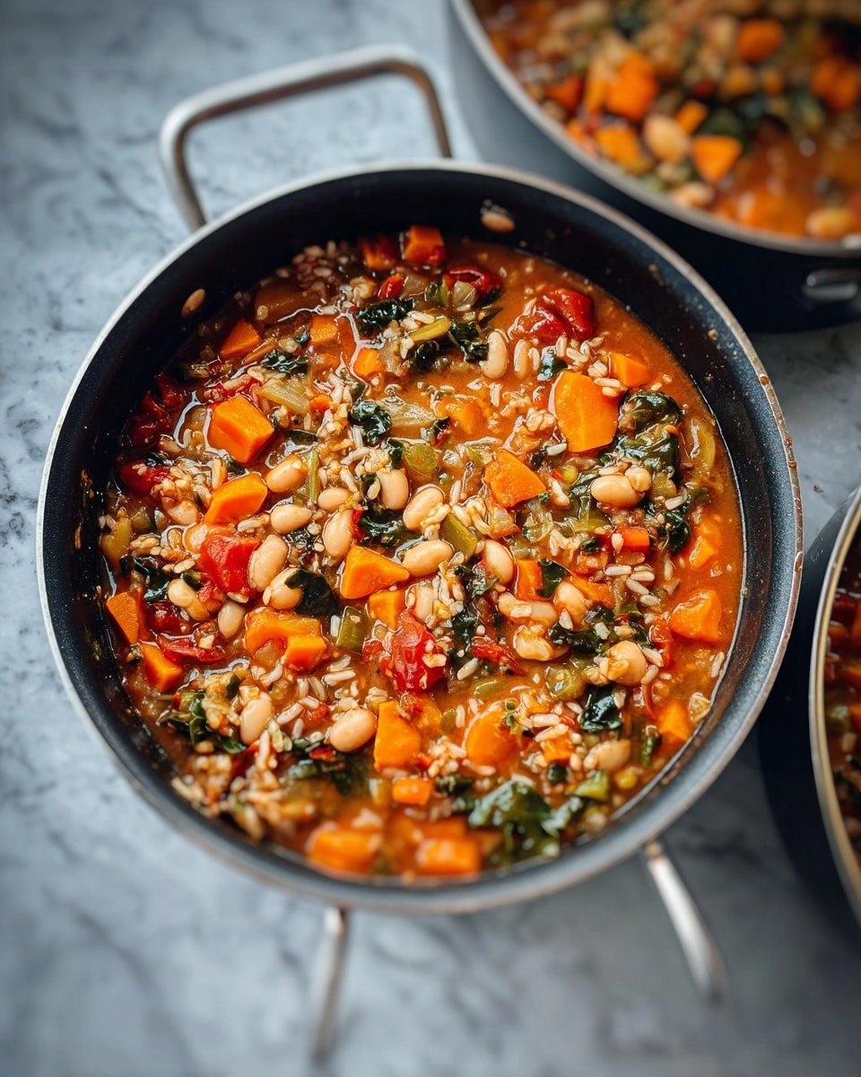 A black pan with silver handles is filled with a colorful vegetable and bean stew. The dish shows many small layers mixed together, including orange carrot cubes, light beige beans, green leafy bits, small red tomato chunks, and scattered grains of brown rice. The stew has a light reddish broth that fills the gaps between the solid ingredients. The pan sits on a white marbled surface, with a blurred second pan partially visible on the side. photo taken with an iphone --ar 4:5 --v 7