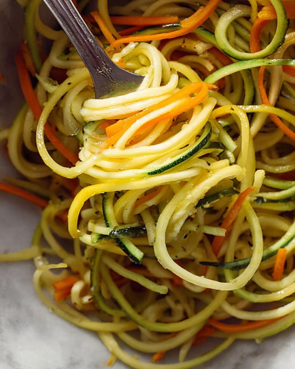 This image shows a close-up of spiralized vegetable noodles, mostly yellow and light green, with thin orange strips mixed in, likely carrot. The noodles are thick and have a slightly shiny, moist look with some texture visible. A silver fork is twirling a small portion of the noodles near the center, lifting them up. The background is a white marbled texture. photo taken with an iphone --ar 4:5 --v 7