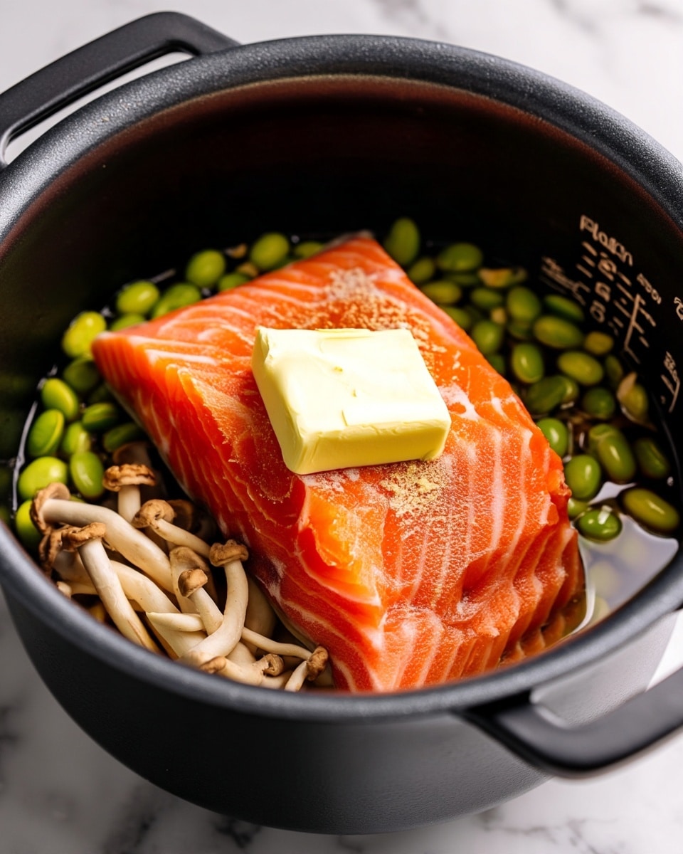Inside a black cooking pot, there is a bright orange salmon fillet with visible white lines on top, centered with a thick square piece of pale yellow butter melting on it. Beneath the salmon, there are small green edamame beans on the left side, and pale beige, long thin mushrooms clustered together on the right side. The pot sits on a white marbled surface. The black pot has white measurement marks on the inside wall. photo taken with an iphone --ar 4:5 --v 7